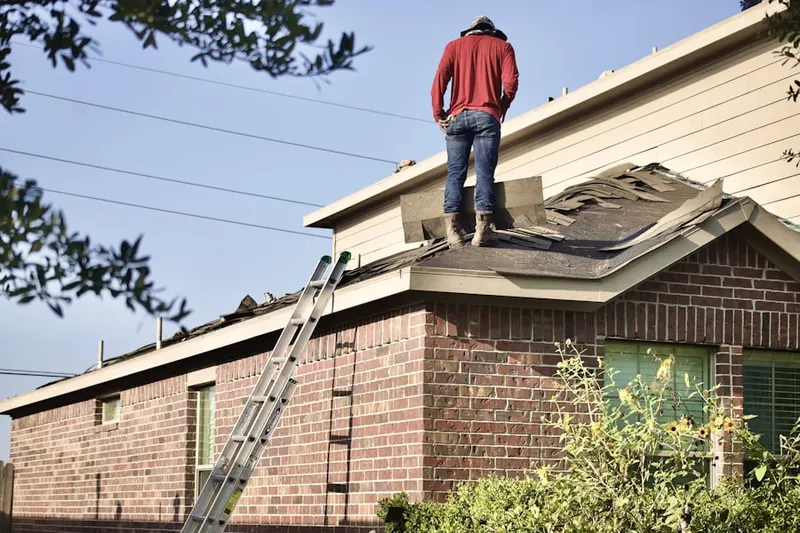 Professional roofer working on a residential roof in Yoder